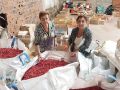 Lola de Queipa y Mari Carmen Ríos supervisando las numerosas cajas y sacas de viruta teñida de distintos colores que almacenan en el Baixo do Lerio