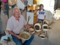 Jesús Pereira con su bisnieta Mía, en su casa de Casadelas, mostrando algunas de sus creaciones
