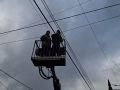 Dos electricistas tratando de arreglar un tendido eléctrico afectado por las tormentas