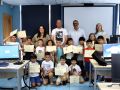 Niños y niñas participantes posando con los representantes municipales tras recibir sus diplomas