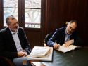 Ricardo Vázquez, de Emalcsca, firma el Libro de Honra acompañado por el alcalde de Zas, Manuel Muíño | cedida