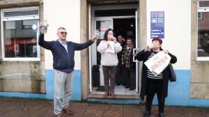 Los responsables del local y clientes brindan por el premio