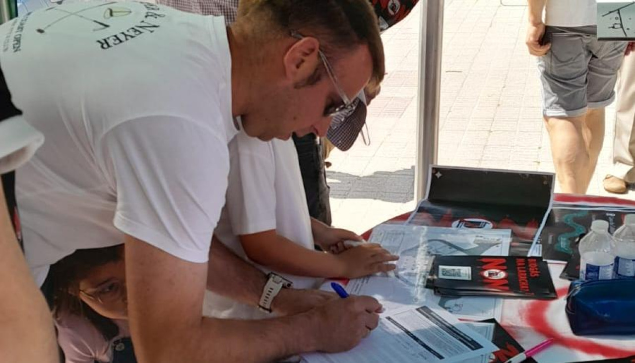 Uno de los visitantes de la feria firmando contra la planta de biogás