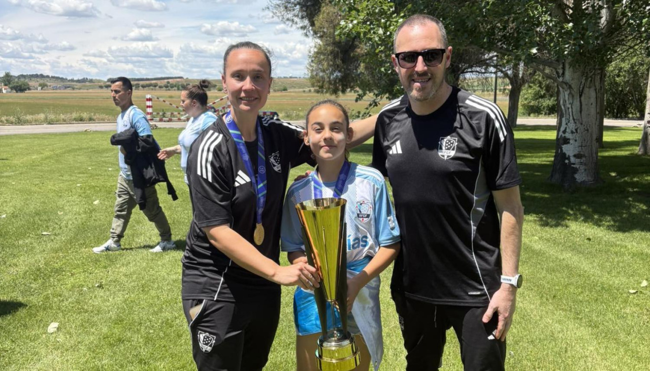 Marina posando con la copa de campeonas de España flanqueada por los enrtrenadores Ana Mouzo y Fran Toba