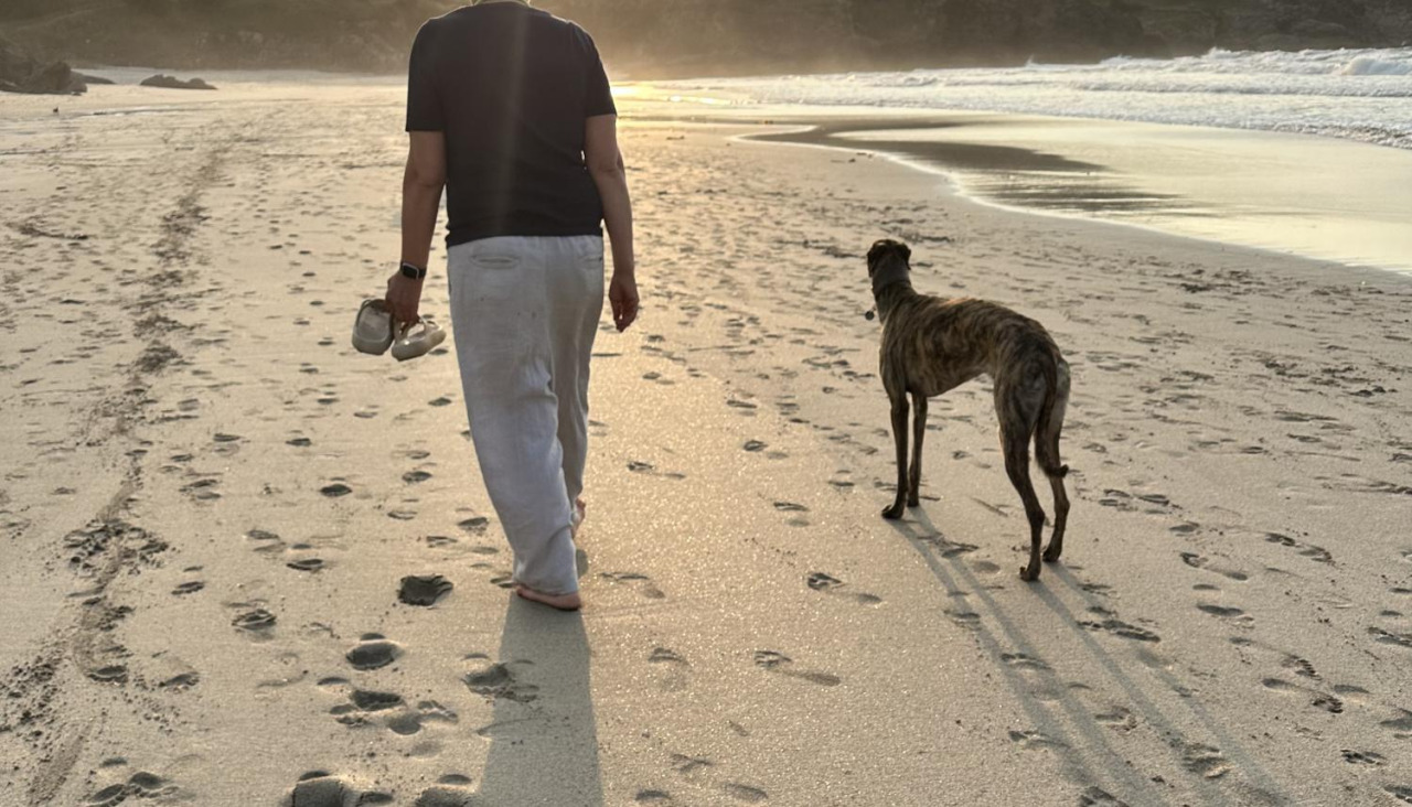 Una vecina de Malpica caminando con su perro por Area Maior