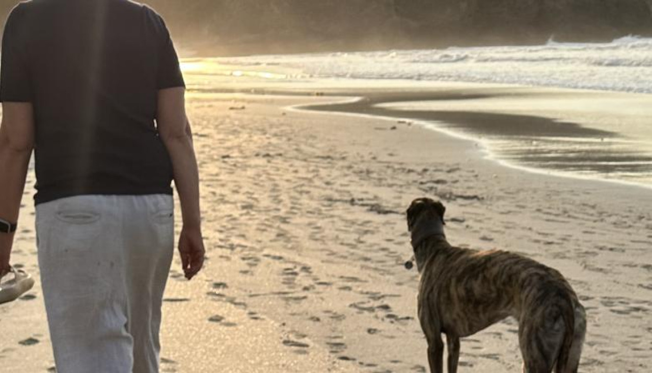 Una vecina de Malpica caminando con su perro por Area Maior