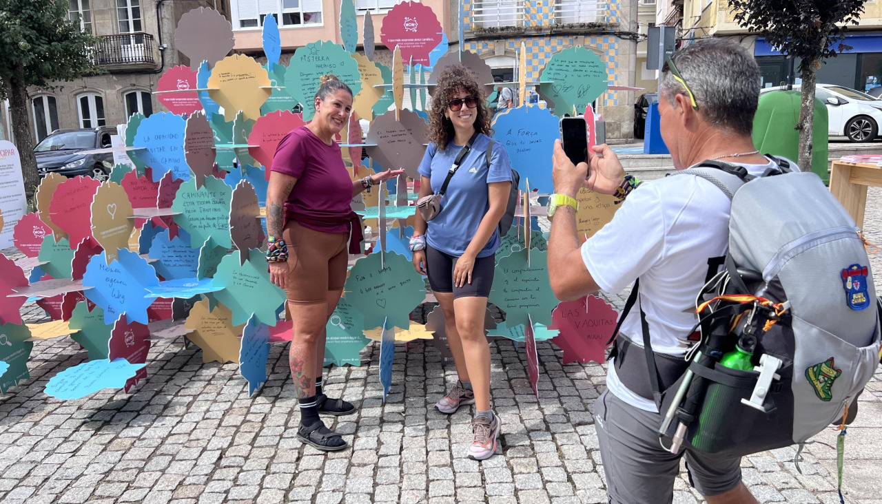 Dos de los peregrinos que dejaron sus impresiones en la escultura que llegó este viernes a Fisterra