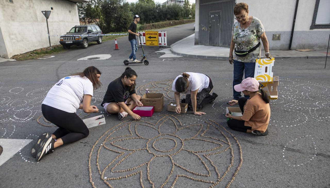 La baixada de carros de bola y la elaboración de las alfombras florales centran la atención de la tarde de fiestas en A Milagrosa