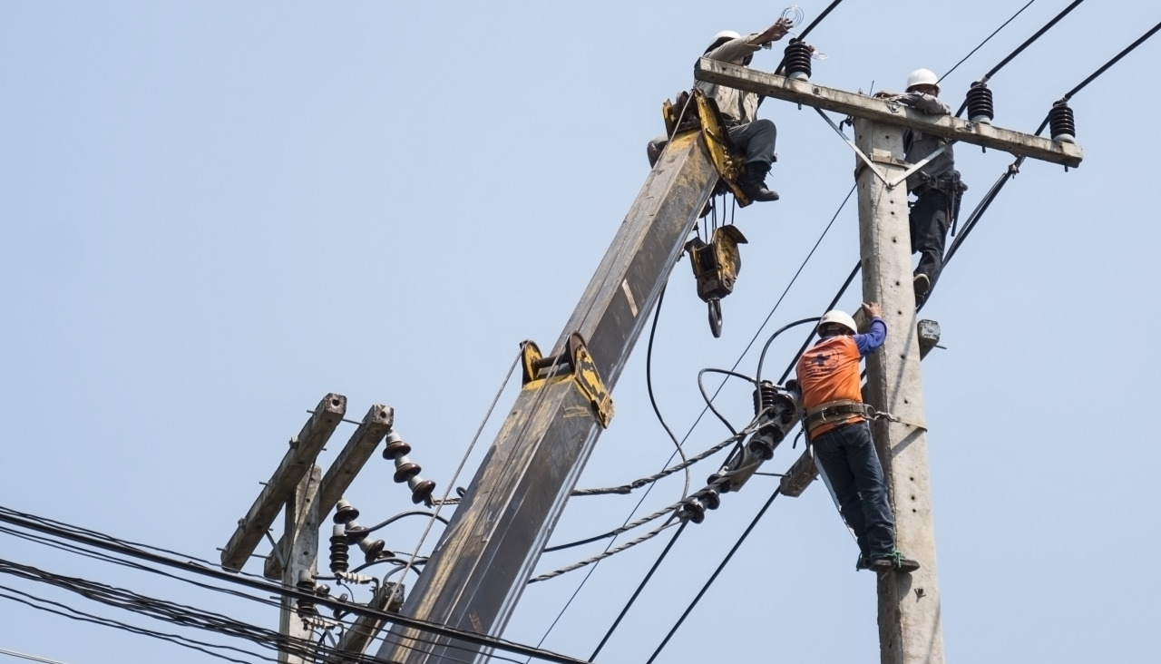 Selective focus electricians are fixing power transmission line electricity pole