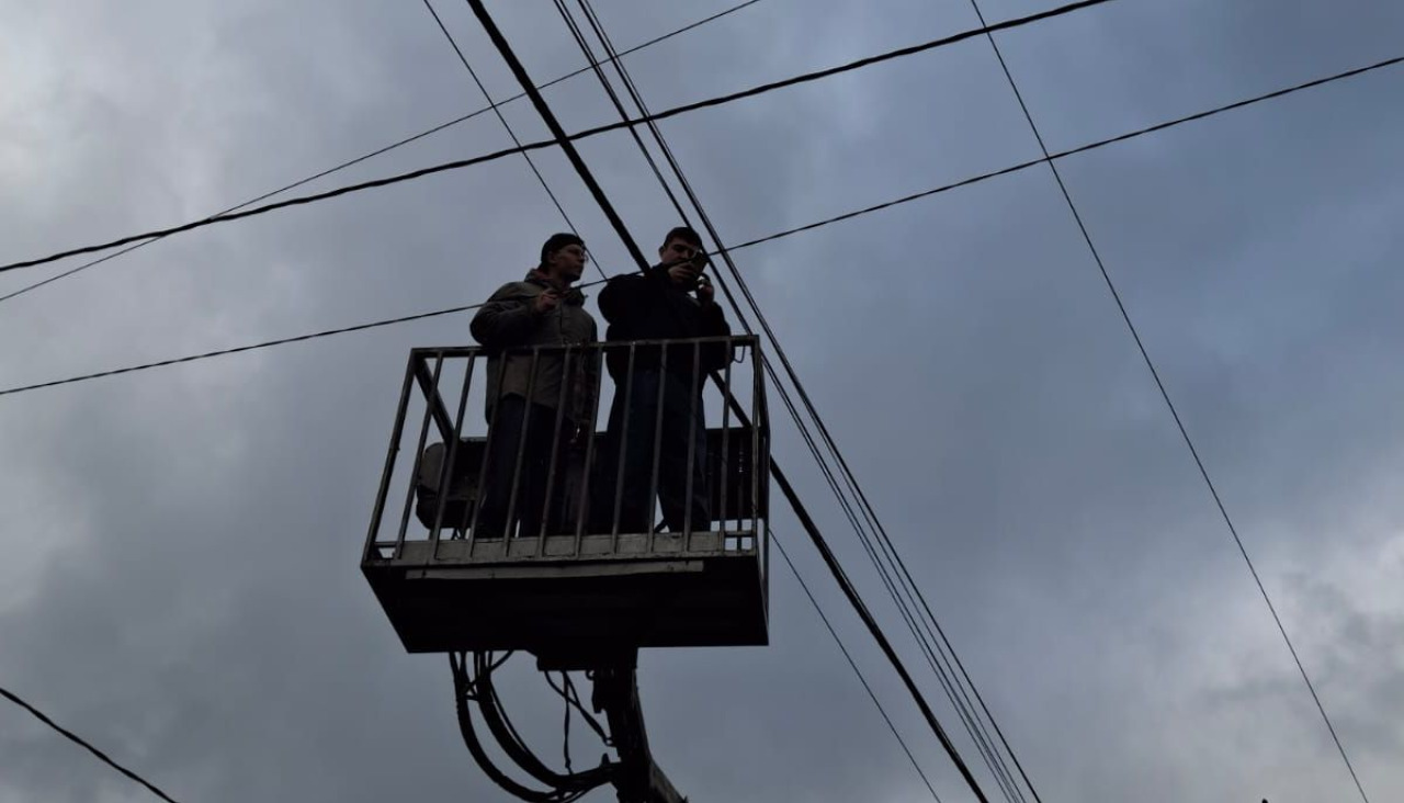 Dos electricistas tratando de arreglar un tendido eléctrico afectado por las tormentas