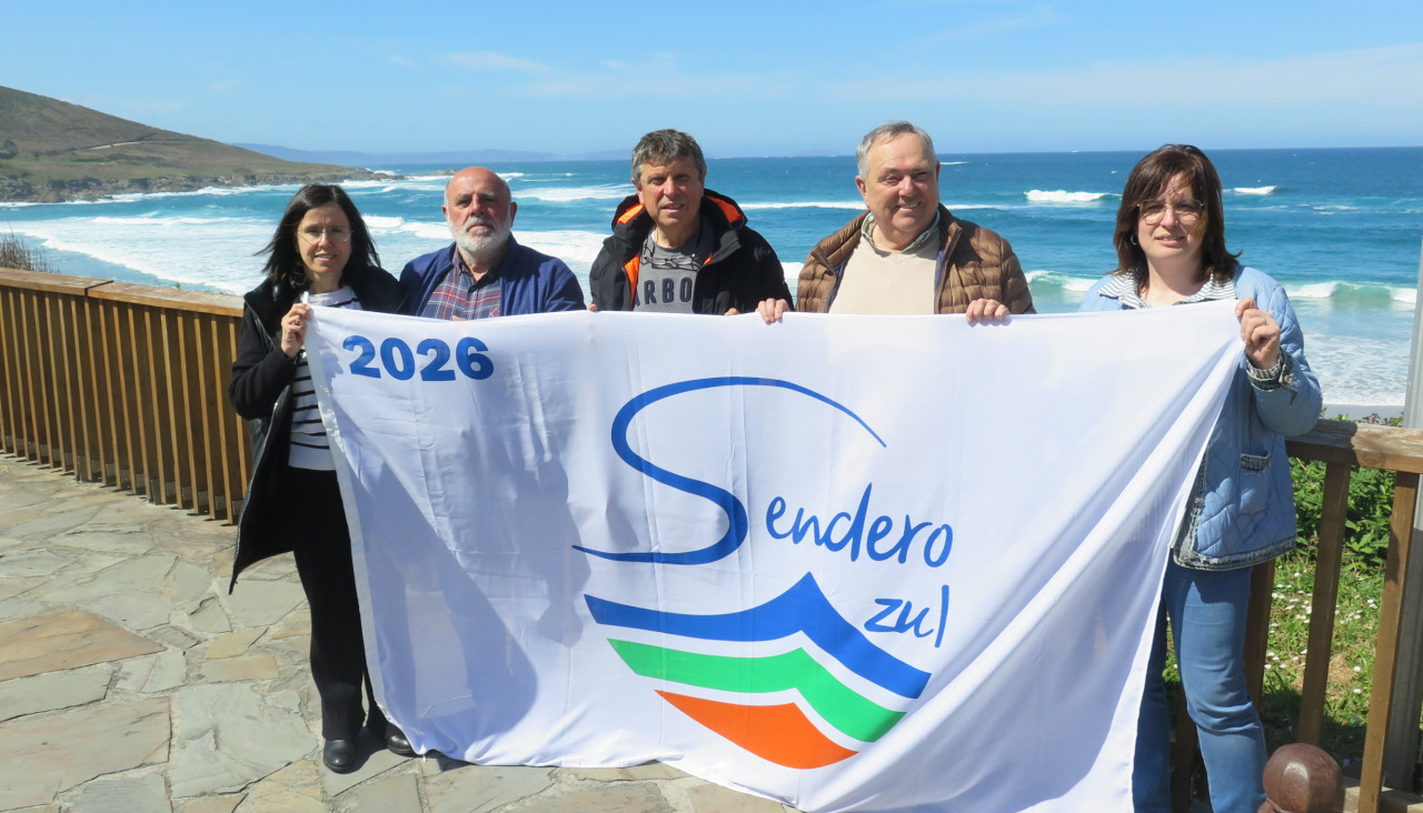Los representantes municipales posan con la bandera antes de proceder a su izado