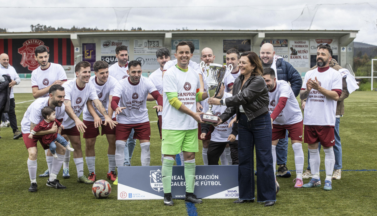 La representante de la RFGF Silvia Cancela entrega el trofeo de campeón a los jugadores del Atlético Carballo