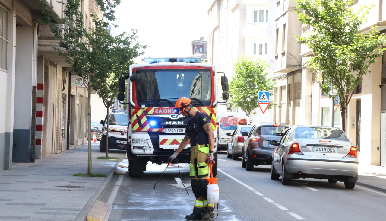 Un bombero aplicando desengrasante para limpiar el vertido