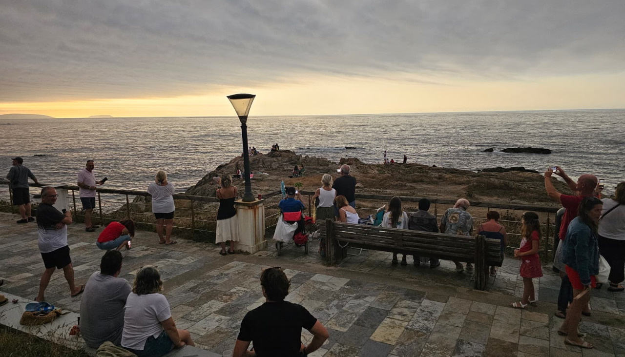 Un grupo de personas observando el eclipse desde el paseo de Caión