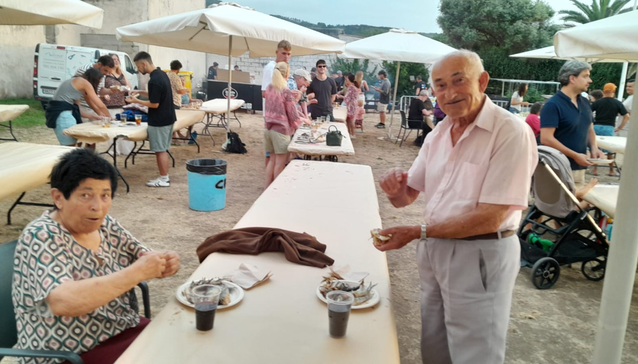 Un grupo de personas degustando sardinas asadas en la Horta do Cura de Caión