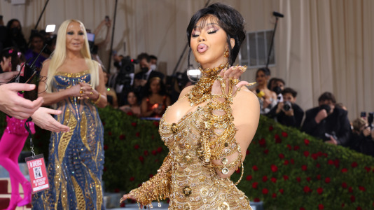 Cardi B y, detrás, Donatella Versace